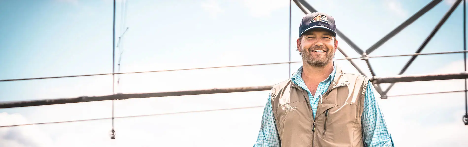 Clay Wehner standing outside with irrigation system behind him.